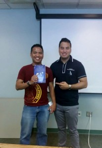 Norman holding the book, The People, Planet, Profit Entrepreneur, written by Valen Vergara